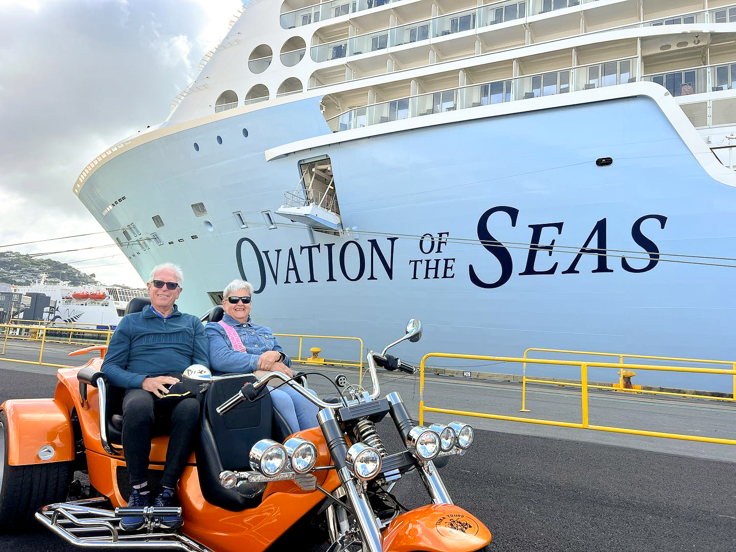 Couple on trike, next to ocean liner